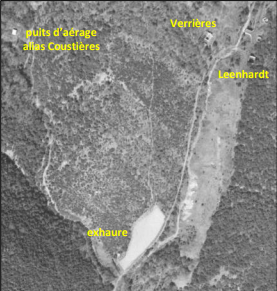 Vue aérienne en noir et blanc un peu pâle. Quatre indications sont écrites en jaune indiquent les emplacement des galerie de mine. On devine le tracé de 2 ruisseaux