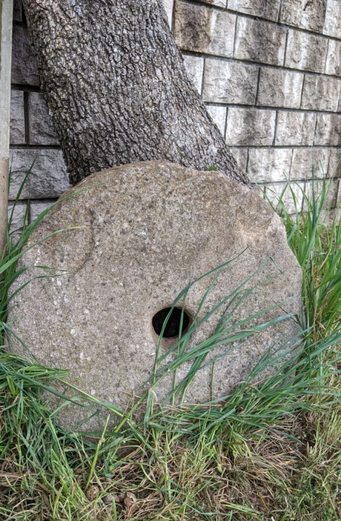 Meule romaine en pierre ronde d'environ 50 cm de diamètre avec un trou dans son milieu