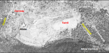 Vue aérienne en noir et blanc pâlie. Deux indication en rouge indiquent le carreau et le terril, 2 autres en jaune indiquent le viaduc et le plan incliné, une en noir indique la carreau d'Alzou et 2 dernières en blanc indiquent les mines